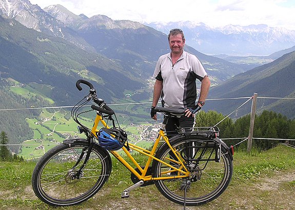 Mann mit Kranich auf einem Berggipfel