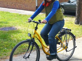 Frau fährt auf einem gelben Fahrrad